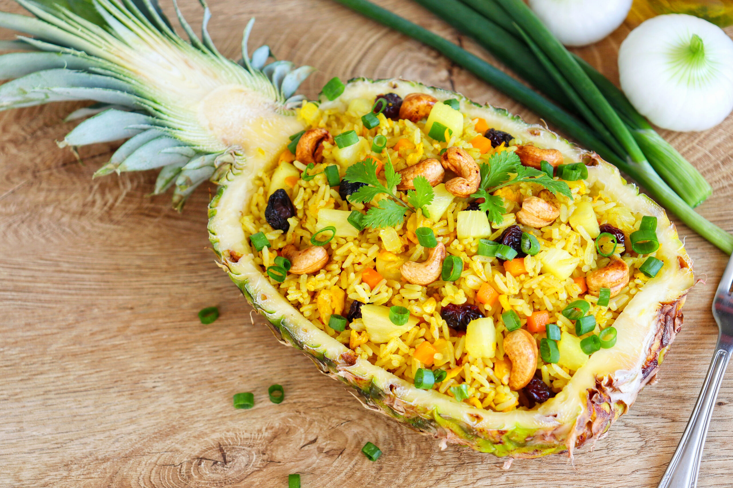 Ananas-Curry-Reis angerichtet direkt in einer Ananas